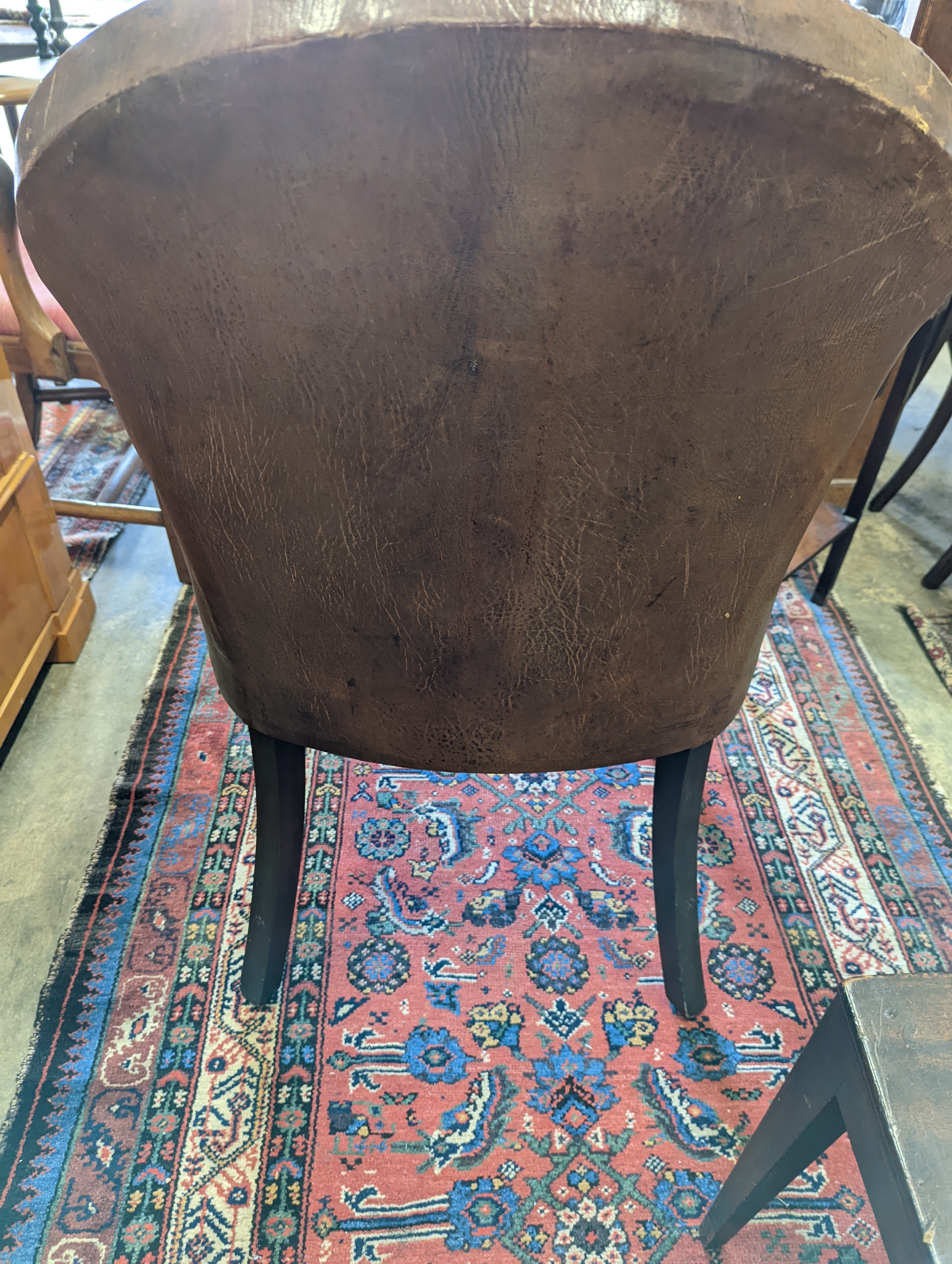 A brown leather upholstered desk chair, a mahogany hall chair and two upholstered armchairs